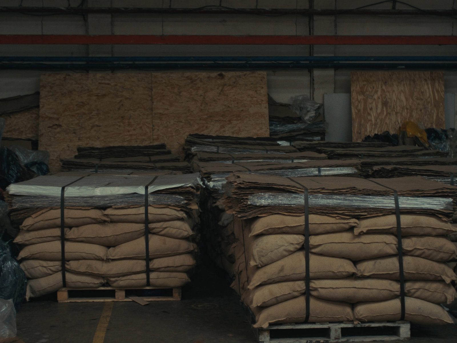 Pallets of sacked green coffee stacked in a warehouse